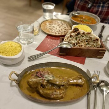 Rooh Columbus - The spread, Lamb Shank Niharri with saffron rice, garlic naan; further back is the Thai Chilies and Cheese Naan with the Butter Chicken! - Indian Near Me - Columbus, Ohio