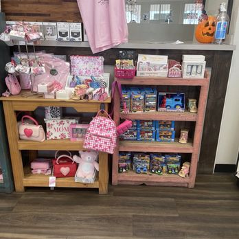 Fairview Pharmacy - Gift items and children's toys - Children's toys, handbags, and gift items are arranged on wooden shelves in a retail store, with some items in pink-themed packaging. - Drugstores Near Me - Espanola, New Mexico