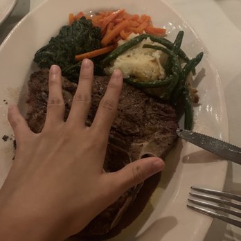 Lelli's Inn - 32oz Dry-Aged Porterhouse (female hand) - Steakhouses Near Me - Auburn Hills, Michigan