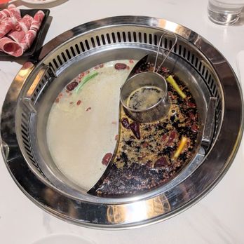 Nice 2 Meet U - Left: Chinese herbal soup. Right: Very mild spicy house special beef tallow flown in from China. Even the very mild is super spicy btw. - Hot Pot Near Me - Doraville, Georgia