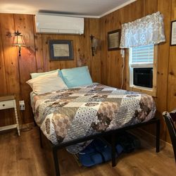 Open Hearth Inn - Crooked bed showing non functioning mini split and window AC unit.
