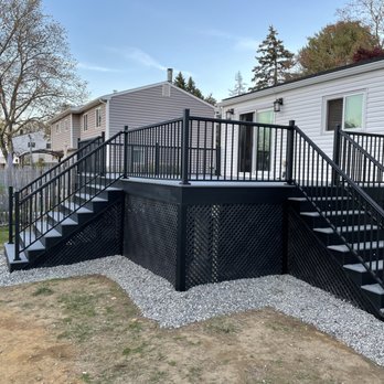 KDH Contracting - a black deck with stairs and railings - Decks & Railing Near Me
