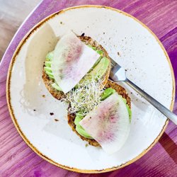 Life Alive Organic Cafe Kendall Square - Avocado Toast with lemon, chili flakes, sea salt, alfalfa sprouts, and radish on a sprouted seed and grain muffin
