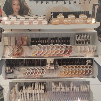 Kohl's - A multi-tiered retail display showcases Fenty Beauty makeup products, including creams, powders, and brushes, with branding and promotional images. - Department Stores Near Me - DEPEW, New York