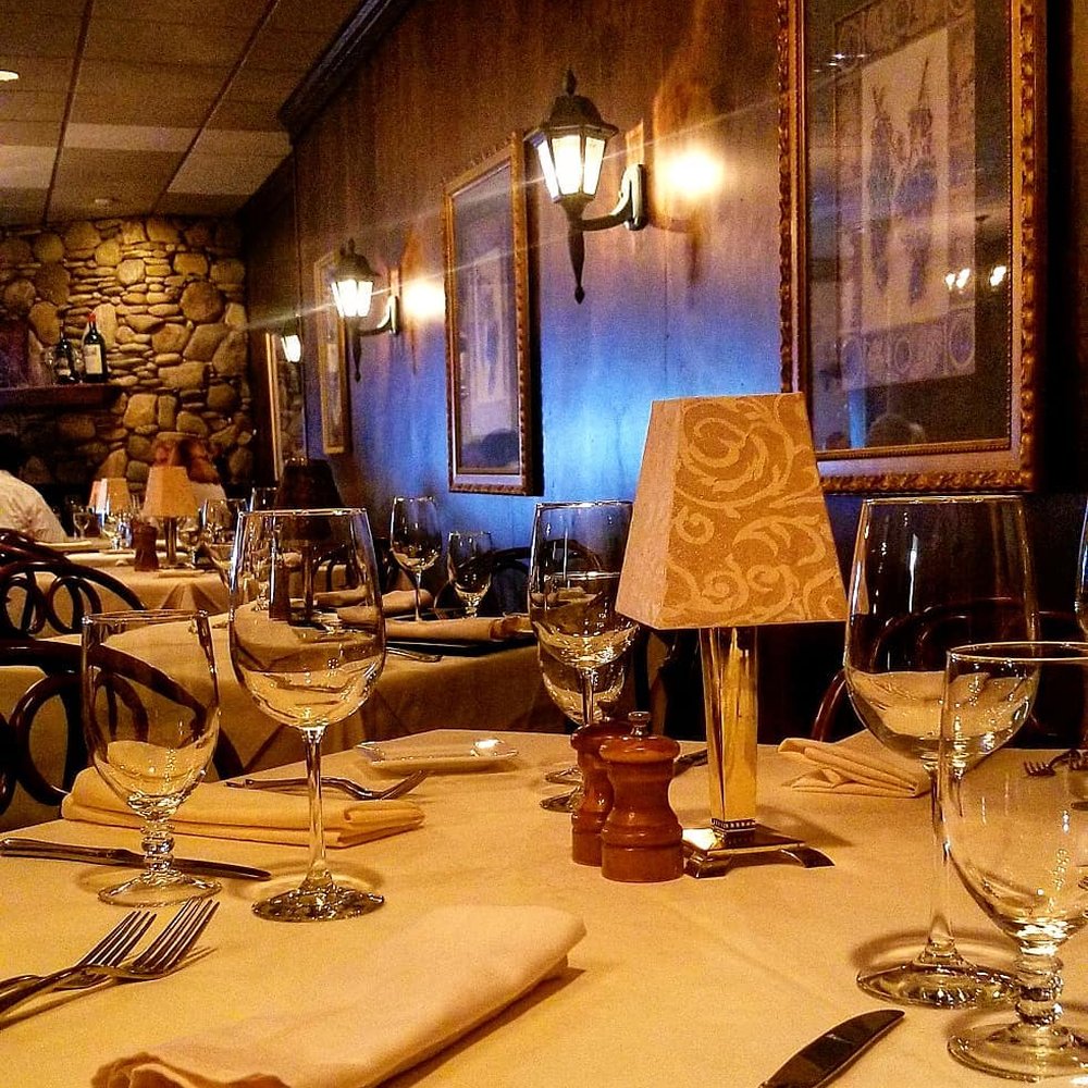 Chez Max Restaurant - a table setting with wine glasses and utensils - French Near Me - Richmond, Virginia