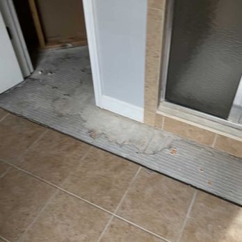 Tough Builders - Water damaged tile in front of shower. - Flooring Near Me Tough Builders - Water damaged tile in front of shower. - Flooring Near Me