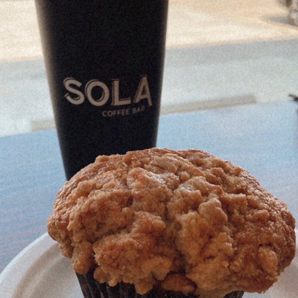 Sola Coffee Bar - Apple cinnamon muffin with bee knees iced latte in their own souvenir cup - Coffee & Tea Near Me - Lynn Haven, Florida Sola Coffee Bar - Apple cinnamon muffin with bee knees iced latte in their own souvenir cup - Coffee & Tea Near Me - Lynn Haven, Florida