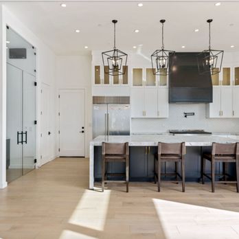 Suburban Tech Design - A chef's dream kitchen with marble countertops, custom cabinetry, and bold black accents. - General Contractors Near Me - Chula Vista, California