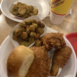 a plate of fried chicken, a roll of breaded bread, and a cup of coffee