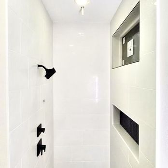 Rhino Renovations - a white bathroom with black hexagon tiles - Flooring Near Me