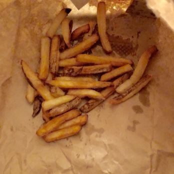 Five Guys - SMALL amount of fries for $5.19!!! - French fries are shown inside a crumpled paper bag, with a small quantity of fries visible. The fries vary in color, with some darker and possibly overcooked. The bag appears to be used for takeout or snack purposes, and the image is taken from above, focusing on the fries' appearance. - Burgers Near Me - Washington, DC, District of Columbia