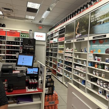 GNC - a man standing in a pharmacy store - Vitamins & Supplements Near Me - Fresno, California