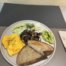 Scrambled eggs, smashed avocado, toast and delicious mushrooms. Scrambled eggs, smashed avocado, toast and delicious mushrooms.