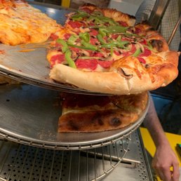 two pizzas on a pizza rack two pizzas on a pizza rack