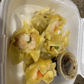 Fat Dragon - Siu Mai (4) - Four shrimp and vegetable dumplings are inside a foam takeout container, accompanied by a small cup of soy sauce. - Asian Fusion Near Me - Austin, Texas