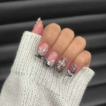 Katie Nails - short-medium acrylic nails with black french tips, flowers, cheetah & tiger print, and a charm - Waxing Near Me - Alameda, California