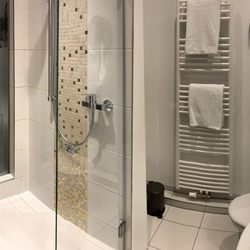 Road Stop Motel Wuppertal - Die Duschkabine des geräumigen und modernen Bads ist mit einer Glasscheibe vom Zimmer getrennt.