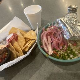 Burrito bowl with pickled onions from the salsa bar and corn tortillas on the side. Burrito bowl with pickled onions from the salsa bar and corn tortillas on the side.