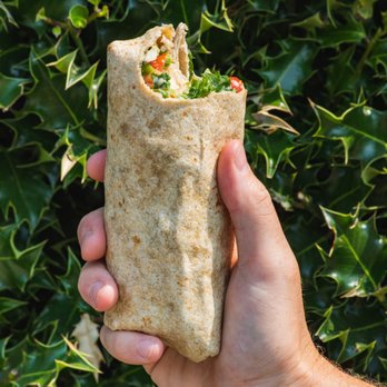 Evergreens - person holding a burrito in their hand - Salad Near Me - Seattle, Washington Evergreens - person holding a burrito in their hand - Salad Near Me - Seattle, Washington