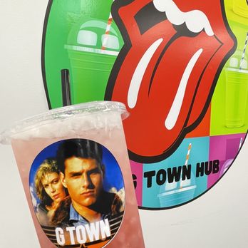G Town Hub - a person holding a drink in front of a rolling stones sign - Juice Bars & Smoothies Near Me - Georgetown, Kentucky