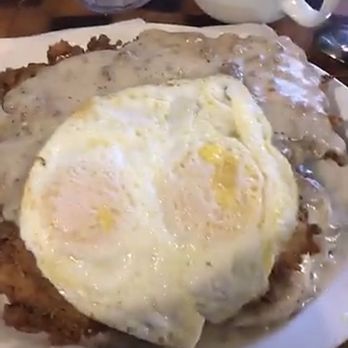 Old West Cafe - 2 biscuits split with gravy, a Chicken Fried Steak on top and 2 over easy eggs. - Breakfast & Brunch Near Me - Grapevine, Texas