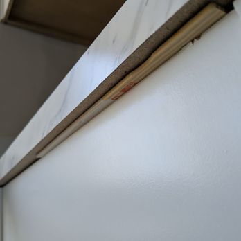 Cutting Edge Construction & Remodeling - A used paint stick used as a shim on brand new cabinets - General Contractors Near Me - Hutchinson, Kansas