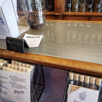 Apothica Teas - A glass jar filled with black peppercorns is positioned on a counter at Apothica Teas, with handwritten labels and a small sign indicating tea flight prices. Behind the jar, there are shelves with numbered tea tins and a wooden display case. Additional informational pamphlets and product displays are also present, reflecting the tea shop's Victorian Steampunk-inspired decor and focus on tea products. - Tea Rooms Near Me - Niles, Michigan