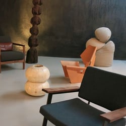 Karkula - Karkula Showroom against "charcoal" plaster wall by Michael Allen. Chair in blue by Token. Blond wood chair by Lange Productions