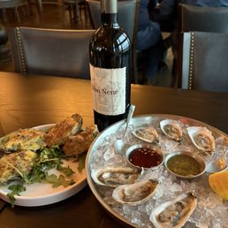 Oysters Rockefeller and oysters on the half shell accompanied by a bottle of Cabernet Sauvignon from Tuscany Oysters Rockefeller and oysters on the half shell accompanied by a bottle of Cabernet Sauvignon from Tuscany