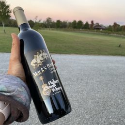 a hand holding a bottle of wine
