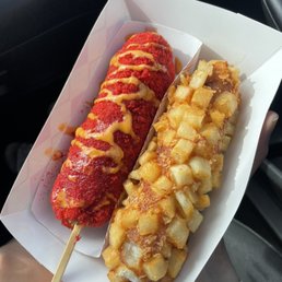 Left: Cheddar hot dog with hot Cheetos Right: hot dog with potatoes Left: Cheddar hot dog with hot Cheetos Right: hot dog with potatoes