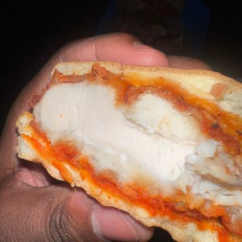 Wingstop - a hand holding a half eaten pizza - Chicken Wings Near Me - Long Beach, California Wingstop - a hand holding a half eaten pizza - Chicken Wings Near Me - Long Beach, California
