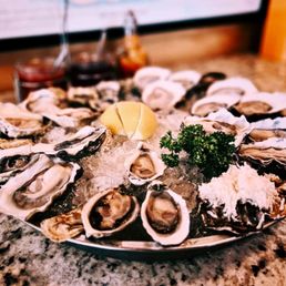 a platter of oysters with a lemon wedge