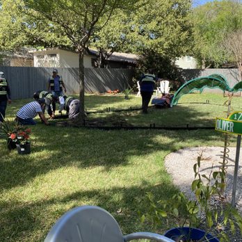 Adam's Lawn Service Austin - a group of people working in the yard - Tree Services Near Me - Austin, Texas