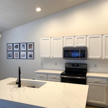 Optimum Home Solutions - a kitchen with white cabinets and black appliances - Flooring Near Me - Queen Creek, Arizona Optimum Home Solutions - a kitchen with white cabinets and black appliances - Flooring Near Me - Queen Creek, Arizona
