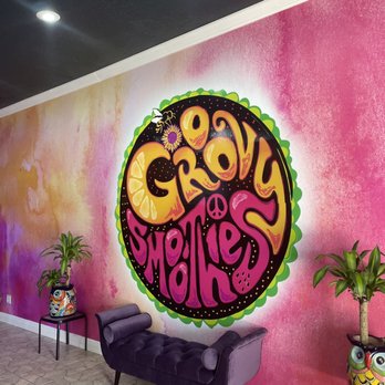 Groovy Smoothies - a woman sitting in a chair in front of a colorful mural - Juice Bars & Smoothies Near Me - Tarpon Springs, Florida Groovy Smoothies - a woman sitting in a chair in front of a colorful mural - Juice Bars & Smoothies Near Me - Tarpon Springs, Florida