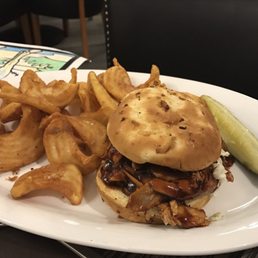 a pulled pork sandwich with onion rings
