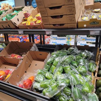ALDI - Veggies - Display of fresh vegetables and fruits such as peppers, avocados, and pineapples in a grocery store produce section. - Grocery Near Me - Exton, Pennsylvania