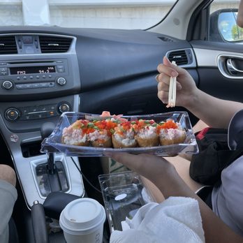 Foodland - a woman holding a tray of food in a car - Grocery Near Me - Kahului, Hawaii