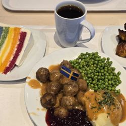 Swedish meatballs, side of plantains, slice of rainbow cake, and coffee