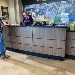 Receptionist on the phone while customers wait.