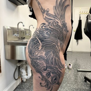 Amour Tattoo - Phoenix black and gray thigh and rib tattoo. - Tattoo Near Me - Falls Church, Virginia