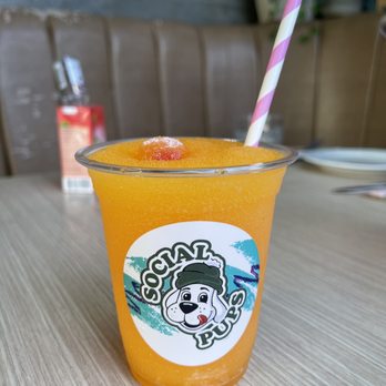 Social - a cup of orange juice on a table - Cocktail Bars Near Me - Vancouver, British Columbia