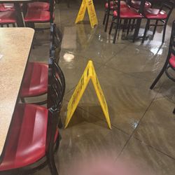 Chicken Express - Wet floor signs hidden from customers entering behind the tables.