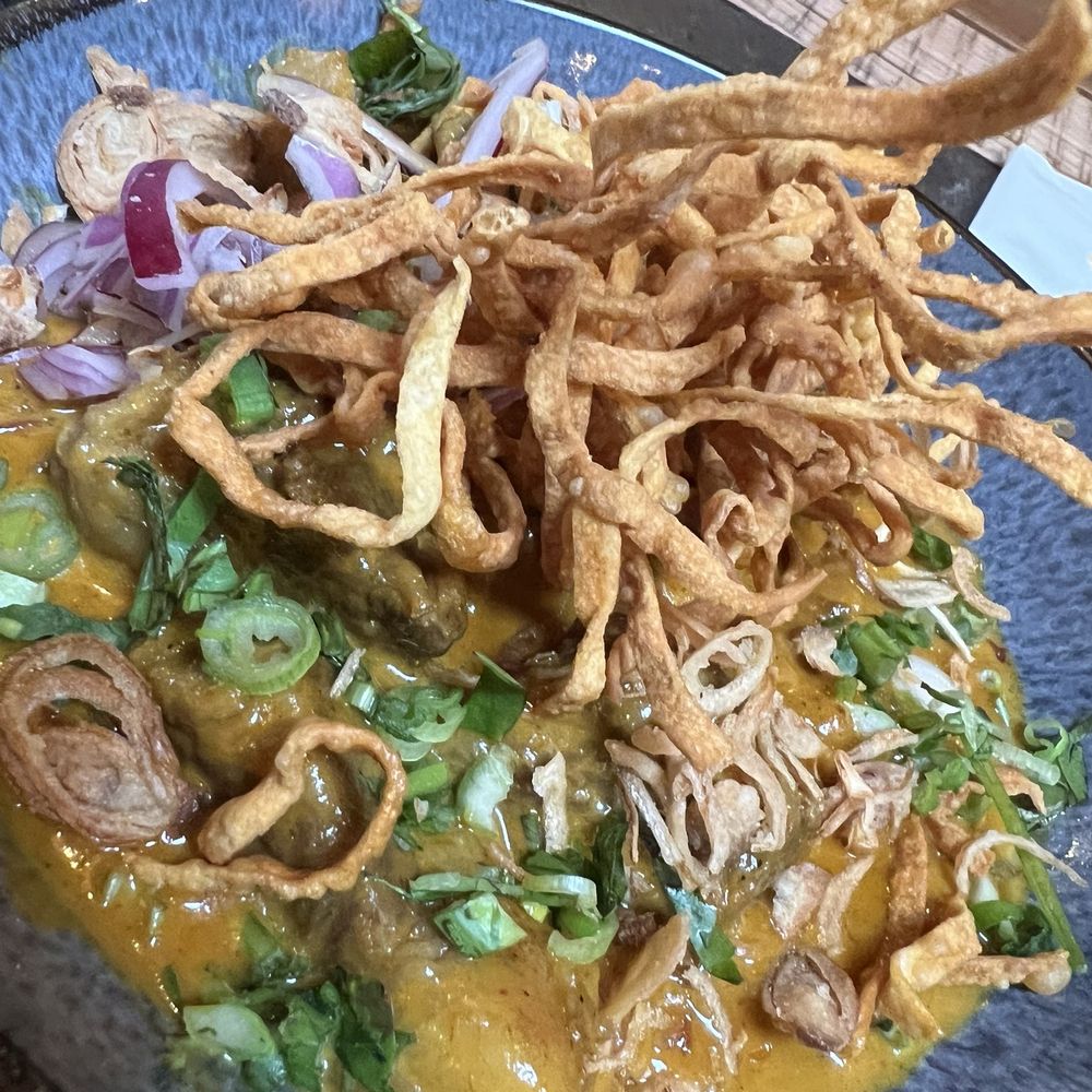 YUI - KhaoSoi (Egg Noodle in coconut milk, braised beef, pickle cabbage, red onion, cilantro topped w/ crispy egg noodles, fried shallots) - Thai Near Me - Portland, Oregon YUI - KhaoSoi (Egg Noodle in coconut milk, braised beef, pickle cabbage, red onion, cilantro topped w/ crispy egg noodles, fried shallots) - Thai Near Me - Portland, Oregon