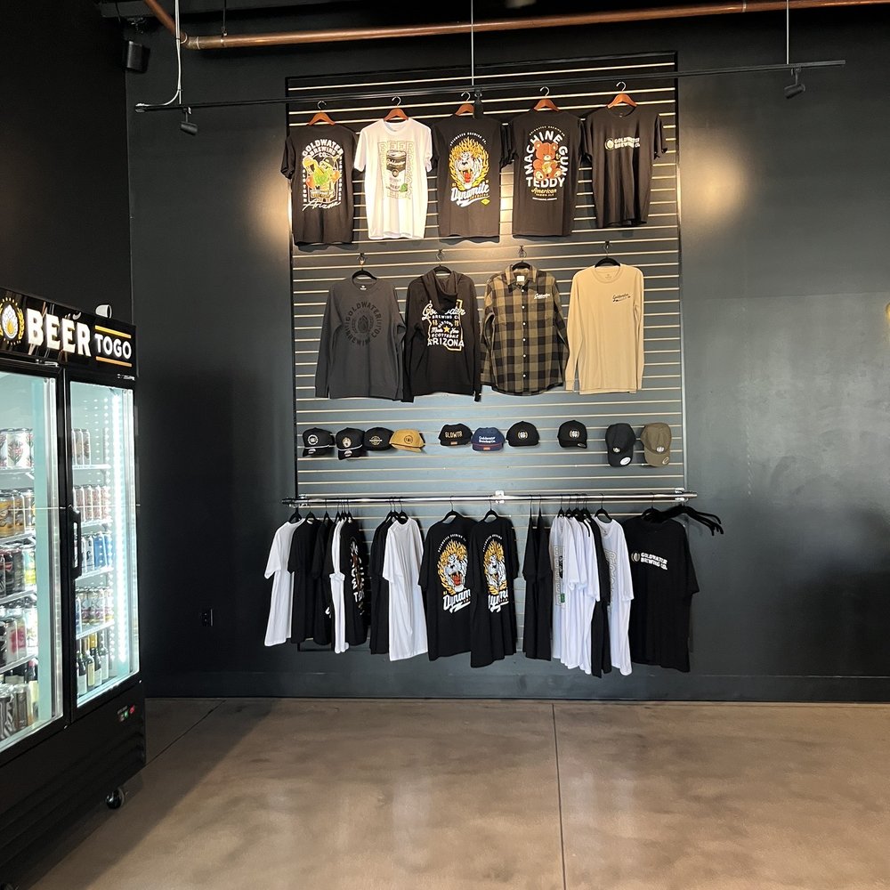 Goldwater Brewing - a display of t - shirts and other merchandise - Breweries Near Me - Tempe, Arizona Goldwater Brewing - a display of t - shirts and other merchandise - Breweries Near Me - Tempe, Arizona