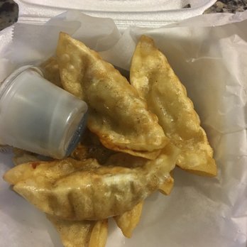 Thai Time - Dumplings, kiddo liked it, but they had packed super hot thing in styrofoam, which I don't like it personally. - Four fried dumplings are placed inside a white foam takeout container lined with paper. A small plastic cup of dipping sauce is positioned on the side of the dumplings. The container is open, revealing the crispy, golden-brown exterior of the dumplings, which are likely served as an appetizer or snack. - Food Trucks Near Me - Austin, Texas