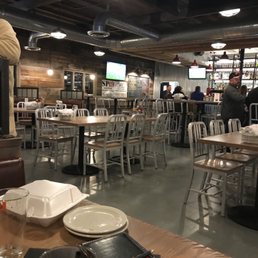 a restaurant with tables, chairs, and televisions