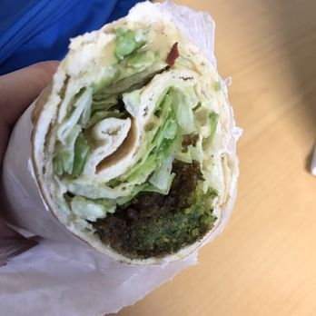 Pita Spot - a hand holding a pita filled with lettuce - Mediterranean Near Me - Orlando, Florida Pita Spot - a hand holding a pita filled with lettuce - Mediterranean Near Me - Orlando, Florida