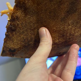 Camellone - Burnt - A person holds a large, fried food item with a crispy, golden-brown exterior, likely a chicken cutlet or similar dish. - Pizza Near Me - Canton, Ohio